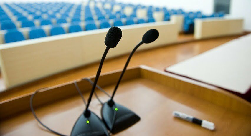 before a conference, the microphones in front of empty chairs.